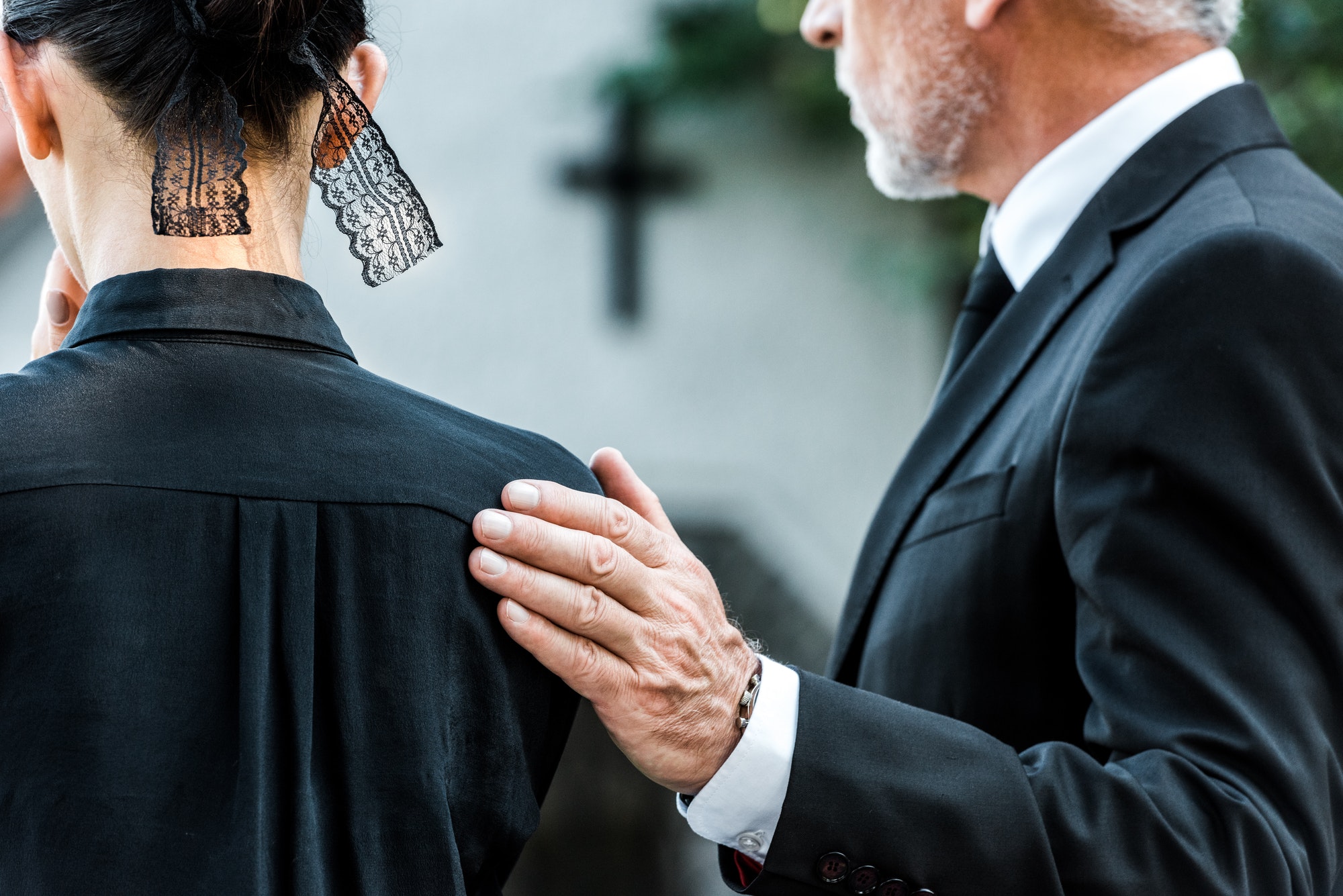 cropped-view-of-man-touching-woman-on-funeral.jpg